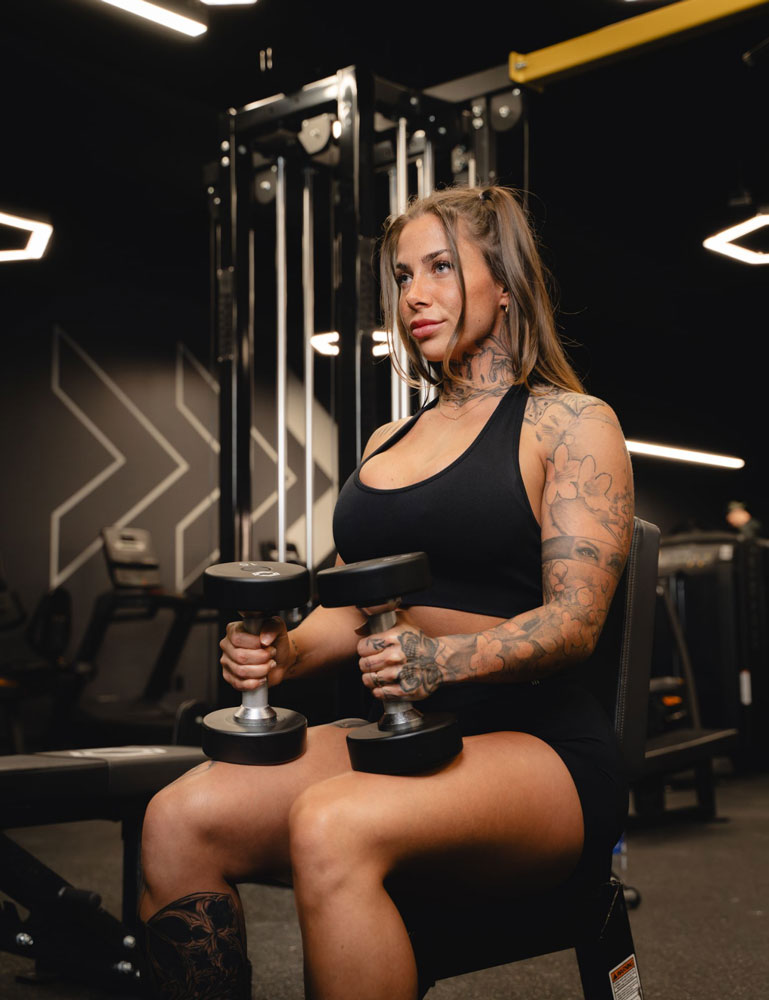 The coach is posing at the gym.